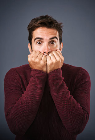 I think we should get outta here. Studio shot of a handsome young man looking scared against a gray...