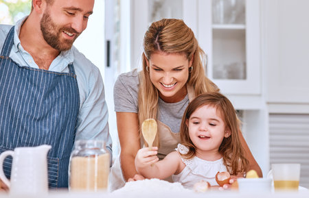 Cooking, family and bakery food in kitchen with child learning, helping and happy with smile. Family...