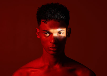 Beauty, red studio and portrait of a man with with a ray of light on his face with a skincare...
