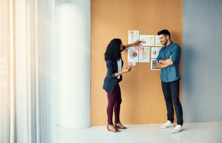 Twice the brainpower on this marketing project. two colleagues having a brainstorming session in a modern office.の写真素材