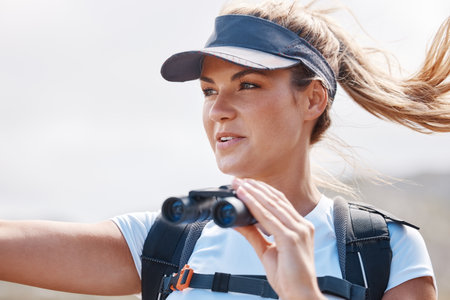 Hiking, holiday and woman with binoculars in nature for travel in Morocco. Adventure, mountains and girl on vacation, trekking and walking with a smile while sightseeing, happy and in summerの写真素材
