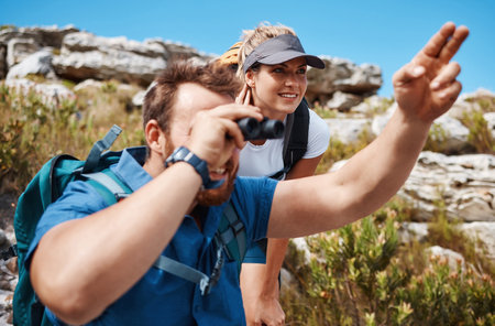 Couple, binocular and hiking in mountain and enjoy view, exercise and fitness in nature while trekking. Freedom, rock and woman with ma, backpack and training for health and wellness outdoor travelの写真素材