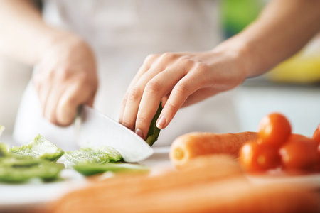 Making something healthy and delicious. Closeup shot of a young woman chopping vegetables in the...