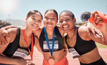 Portrait, diversity and women with medals, for sports and winners on track, smile or victorious together. Champions, healthy girls or athlete happy with results on field, running victory or happinessの写真素材