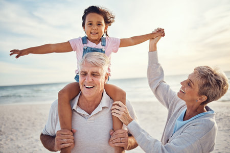 Beach, family and grandparents piggy back for holiday fun together with grandchild in Australia....