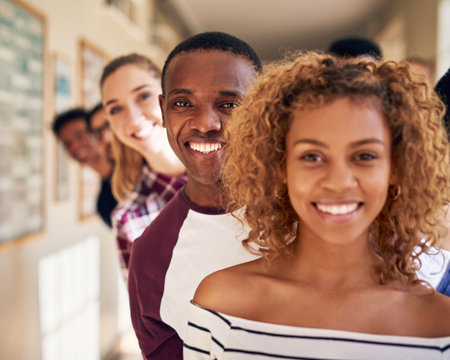 Confident and capable of amazing things. Portrait of a diverse group of students standing in a line at campus.の写真素材
