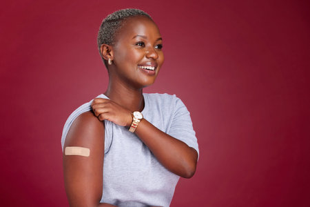 Covid, vaccine and arm with a black woman in studio on a red background with mockup to promote...