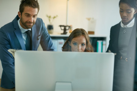 Focused on finding the solution they need. colleagues working together on a computer in an office.