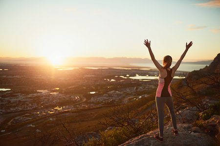 Ultimate freedom. Rearview shot of a sporty young woman standing outdoors with her arms...