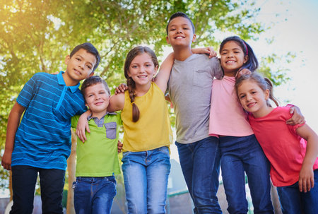 Our friendship starts now but will never end. a diverse group of children holding each other...