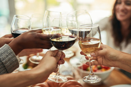 Heres to the good times. a group of people making a toast at a dining table.の写真素材