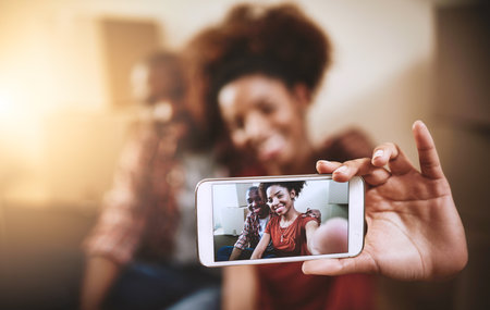 The moment is finally here. a young couple taking a selfie in their new home.の写真素材