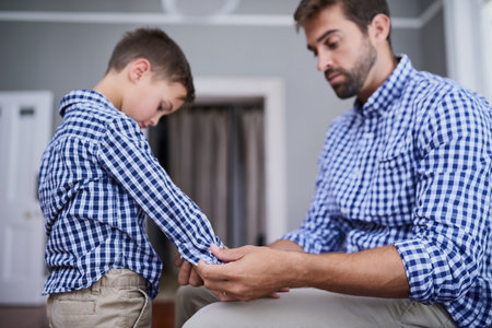 Dressing up just like dad. a handsome young man and his son getting dressed in the morning.の写真素材