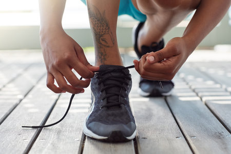 Lace up before you shape up. a sporty young woman tying her shoelaces.