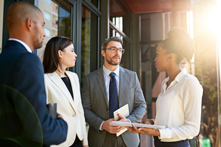 Everyones input is vital. a diverse group of businesspeople having a meeting on a balcony in bright sunlight.の写真素材