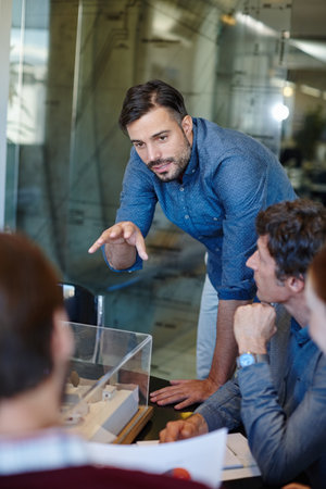 Weve come up with a great solution here. a group of architects having a meeting in their boardroom.の写真素材