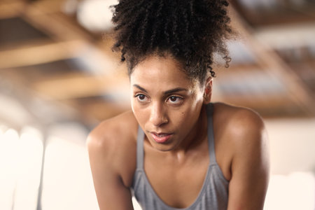 Tired, fitness and woman after a gym sport, workout and training exercise run in a wellness club. Breathe recovery of an athlete sweating from sports, running cardio and strong runner jog for healthの写真素材