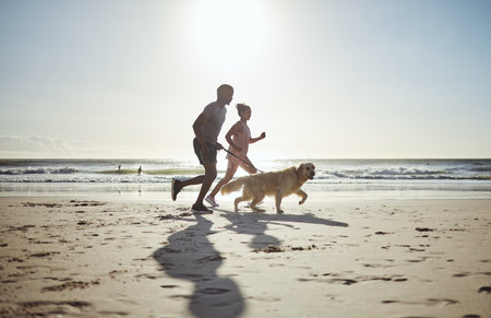 Couple, beach and running with dog for health, wellness or exercise. Mock up, diversity and man, woman and animal outdoors on sports run, exercising or workout jog on sandy seashore or ocean coast.の写真素材