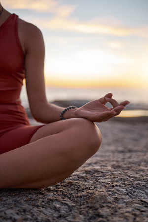 Hand, woman and yoga at the beach at sunset, zen and relax exercise, mudra and chakra training with mockup. Meditation, hands and girl meditating at the sea, peace and energy in nature environmentの写真素材