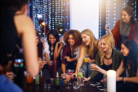 Taking a round with the girls. a group of friends having shots together at a party.