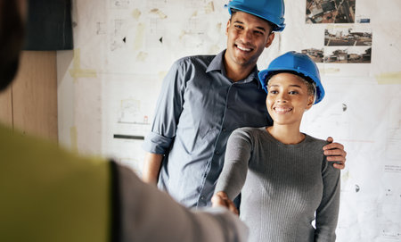 Handshake, engineering and architect in a b2b partnership deal with a successful industrial company. Smile, hiring and happy woman in leadership shaking hands with a construction worker for a new jobの写真素材