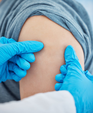 Touching, medical and hands of a doctor on an arm of a patient before a vaccine at a hospital. Test, healthcare and worker in medicine doing a check, consultation and help with pain in shoulderの写真素材