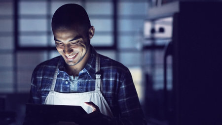 Late night browsing. a young man working late on a digital tablet in his coffee shop.