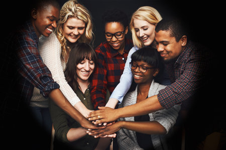 In it to win it. a group of cheerful work colleagues forming a huddle together.の写真素材