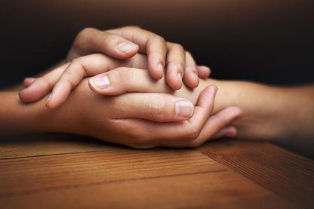 We can get through this together. two unrecognizable people holding hands in comfort.
