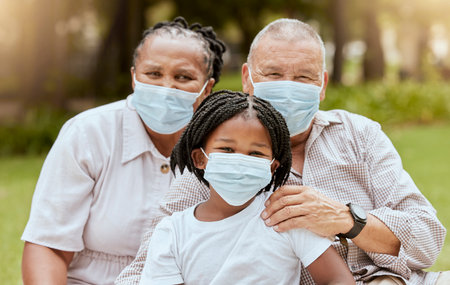 Family portrait, covid and face mask outdoor at nature park with child and grandparents together on picnic for love, care and summer bonding. Man, woman and girl with covid 19 safety complianceの写真素材
