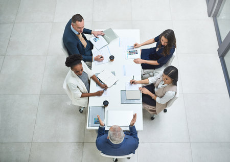 Envisioning success together. High angle shot of businesspeople having a meeting in a modern office.の写真素材