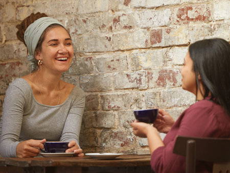 Business meeting, coffee or friends networking in restaurant or cafe for communication, planning or talking for startup company. Happy, women or consulting people for social business strategy in cafeの写真素材