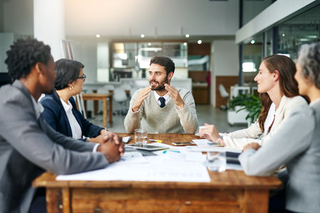 Sharing his vision with the team. a group of businesspeople meeting in the boardroom.の写真素材