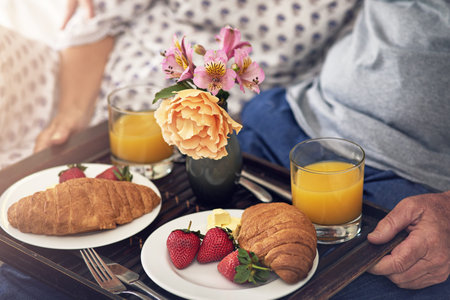 Treat your wife with breakfast in bed. a senior couple having breakfast in bed.