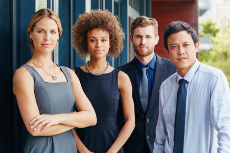 Determined to be the best in the business. Portrait of a group of focused young professionals standing together outside.の写真素材