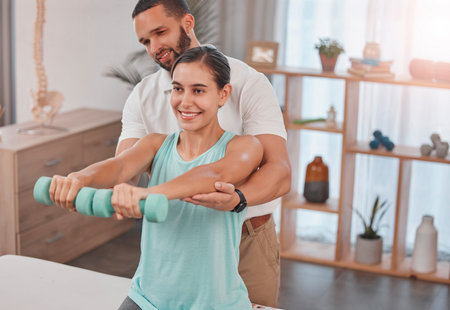 Physiotherapy, exercise and dumbbells with a man therapist and woman client in a rehabilitation...