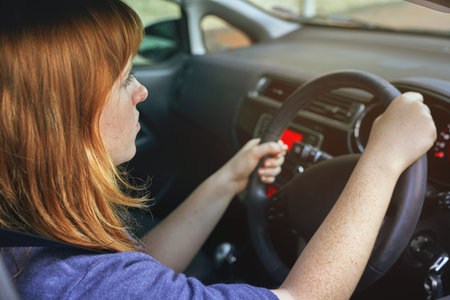 Focused on the road ahead of her. a young woman driving a car.
