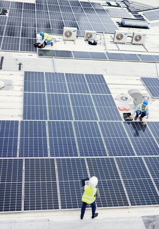 Solar panel, construction and industrial employees on roof for solar energy, engineering and...