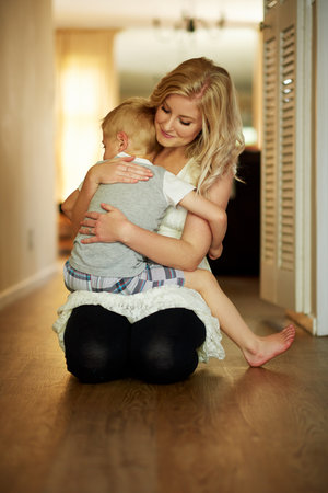 Moms cuddles are the most comforting. a little boy being comforted by his mother at home.の写真素材
