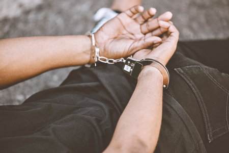 Arrest, justice and thief in handcuffs for fraud, violence and burglary after a suspected house robbery. Law, hands and gangster criminal going to jail or prison for violence and crime in Venezuelaの写真素材