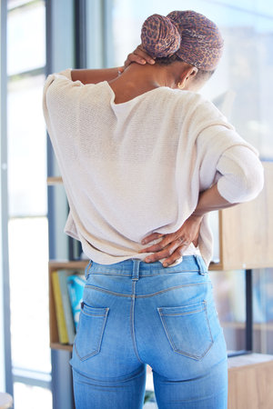 Black woman, back and neck pain in stress, tired or overworked from working at home. African...