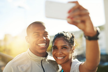Post-workout selfie. a young sporty couple taking a photo together with a cellphone.の写真素材