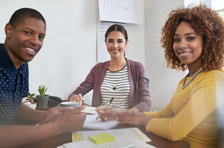 We all share the benefit of teamwork. Portrait of a group of colleagues having a meeting in a modern...