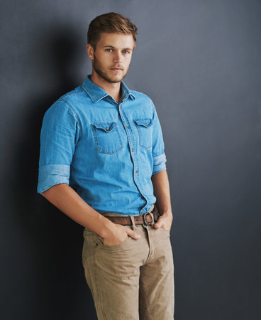 I refuse to be anything but successful. Studio shot of a young man standing against a dark background.の写真素材