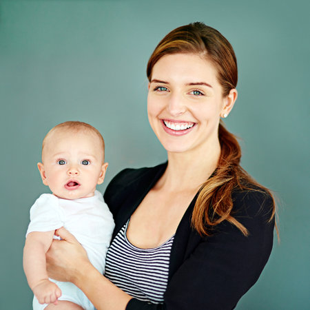 I want to provide the best for my little boy. Studio shot of a successful young businesswoman carrying her adorable baby boy.の写真素材