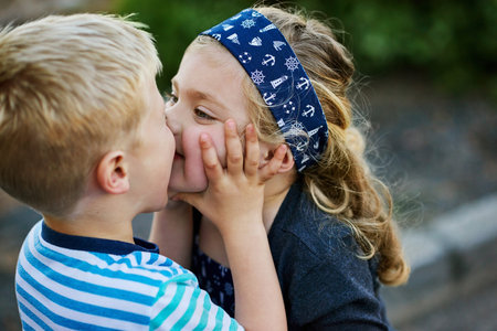 Theyre not afraid to show a little affection. a little girl giving her brother a kiss while they...