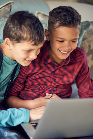 The tech savvy generation. a two young boys using a laptop together at home.