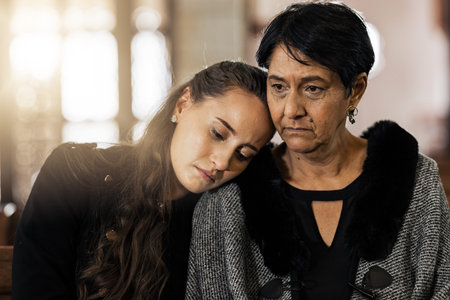 Sad, empathy and funeral with women in church for mourning, grief and death. Loss, respect and...