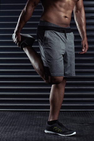 Getting ready for a workout. an unrecognizable man stretching before a workout.