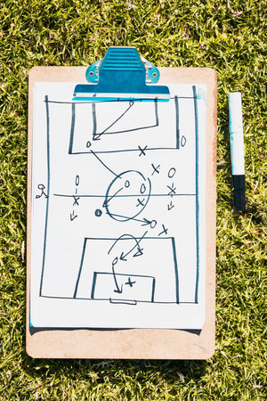 Sports, soccer field and clipboard planning a strategy for a group mission, target or tactics for goals. Solutions, teamwork and coach drawing winning tactics or ideas on grass in a football stadiumの写真素材